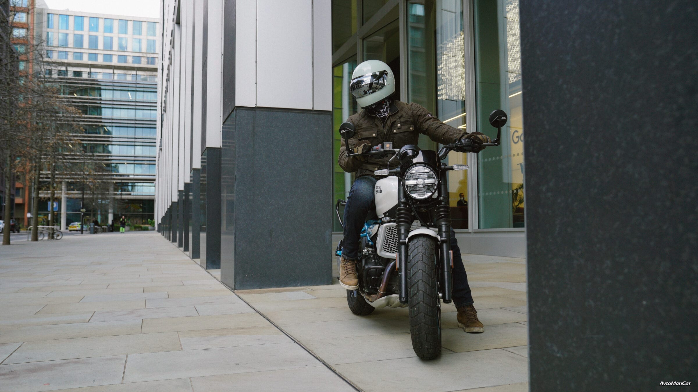 Мотоциклист позирует на Royal Enfield Guerrilla 450, смотрит влево.